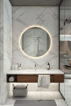 a bathroom with marble walls and flooring, a round mirror on the wall above the sink