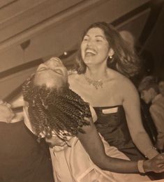 an old photo of a woman laughing and holding another woman's head in her arms