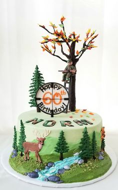 a birthday cake decorated with trees and deer