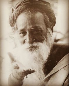 an old black and white photo of a man with a long beard wearing a turban