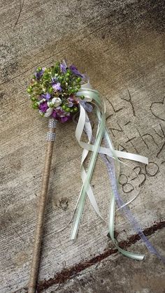 a bouquet of flowers laying on the ground next to a pole with writing on it