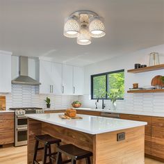 a kitchen with an island and two stools in front of the stove top oven