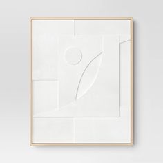 a white framed artwork piece on the wall with a wooden frame and an abstract design