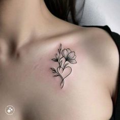 a woman's chest with a flower tattoo on the left side of her breast