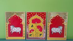 three red and yellow greeting cards with cows on them, sitting on a shelf in front of a green wall