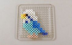 a beaded bird sitting on top of a plastic container