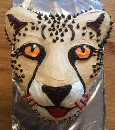 a cake in the shape of a cheetah's head with orange eyes