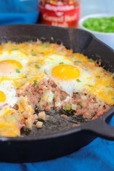 two eggs are being cooked in a skillet on a blue towel next to other dishes