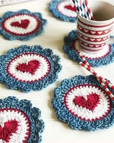 crocheted coasters with red, white and blue designs on them sitting on a table