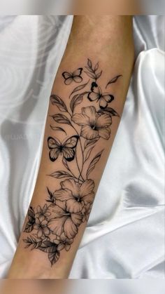 a woman's arm with flowers and butterflies on it