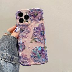 a person holding an iphone case with purple flowers on it