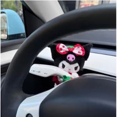 a stuffed animal is sitting in the driver's seat of a car with steering wheel