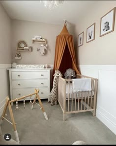 a baby's room with a crib, dresser and other items in it