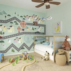 a child's bedroom decorated in blue and green with toy train tracks on the wall