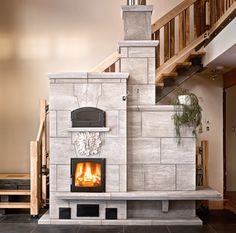 a fire place sitting in the middle of a living room next to a stair case