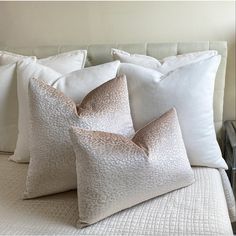 three white pillows sitting on top of a bed