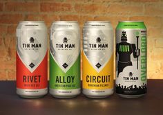 four cans of tin man ale on a table in front of a brick wall,