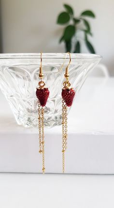 "Strawberry Fruit Chain Earrings for your daily dose of quirky and fun { D e s c r i p t i o n } These earrings have all it takes to make an appearance! With a simple design, they are made with gold plated chains and a enamel strawberry pendants. The satellite chains dangles gently,  framing and elongating your face. They have a gorgeous gold finish and are made of brass. The golden French hooks accessories are gold plated. Rubber back stoppers included. Perfect to wear daily on hot summer days, to gift it to a gardening lover or even someone who enjoys fruits and quirky accessories.   { Si z e } 8 cm / 3.2\"  long 1.2 cm strawberry pendants  please note, jewelry might change color due to moist and chemical exposure. Wipe with a soft cotton cloth and avoid exposure to elements  ♥ Please re Trendy Red Dangle Jewelry, Novelty Dangle Jewelry With Charms, Novelty Jewelry With Dangling Charms, Red Novelty Drop Earrings, Red Earrings With Dangling Charms For Gift, Valentine's Day Novelty Dangle Earrings, Valentine's Day Novelty Dangle Jewelry, Red Novelty Jewelry As Gift, Red Novelty Jewelry For Gift