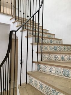 a set of stairs with blue and white tiles on the treads in a home