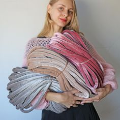 a woman holding several pieces of fabric in her hands