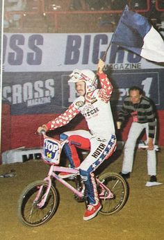 a man riding on the back of a bike holding a flag