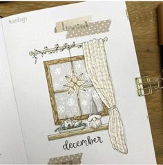 an open notebook with a drawing of a window and the words december written on it