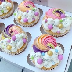 six cupcakes with different colored frosting and decorations on them in a box