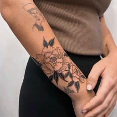 a woman with a flower tattoo on her arm