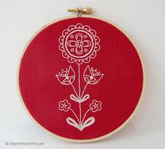 a red embroidery hoop with white flowers on it