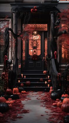 an entrance to a house decorated for halloween with pumpkins on the ground and candles lit