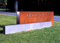 a sign that reads pennington college on the side of a road in front of some grass