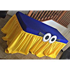 a blue and yellow table cloth with eyes on it in the shape of a car