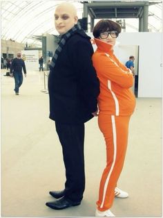 two people dressed in orange and black standing next to each other