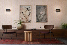 two chairs sitting next to each other on top of a red rug in front of a wooden table