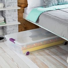 a white bed sitting next to a book shelf on top of a wooden floor