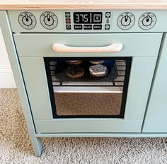 an oven with some food in it on top of carpeted floor next to wall