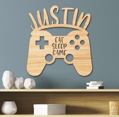 a wooden sign that says eat sleep game on the side of a shelf in front of a bookcase