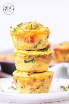 three muffins stacked on top of each other with tomatoes and herbs in the background