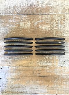 four pairs of black hair clips sitting on top of a wooden table