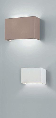 two square lights mounted on the wall next to each other, one light is off