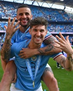 two soccer players hugging each other in front of a stadium full of people and confetti