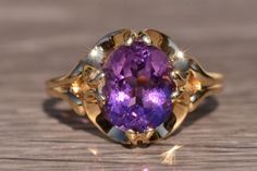 The Henly: Interesting Amethyst Ring in Yellow Gold. The ring features a oval brilliant cut natural vivid purple amethyst in the center with a total weight by measurement of 2.50 carats in a flared eight prong setting. The buttercup design of the setting hugs the center stone connecting it to the very slightly split shank offering an elegant French look. The ring is crafted in 14 karat yellow gold and is currently a finger size 8 1/4 yet can be adjusted to any finger size for an additional charg Timeless Oval Purple Amethyst Ring, Oval Amethyst Ring With Center Stone For Formal Occasions, Purple Ruby Ring For Formal Occasions, Classic Oval Amethyst Ring, Oval Amethyst Ring With Brilliant Cut For Anniversary, Oval Purple Amethyst Ring With Center Stone, Heirloom Purple Amethyst Ring For Formal Occasions, Heirloom Solitaire Purple Amethyst Ring, Timeless Purple Oval Amethyst Ring