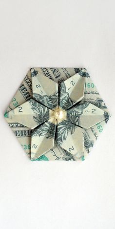 an origami flower made out of dollar bills on a white background with light