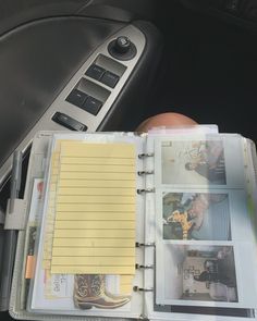 a car dashboard with a notepad and pen on it next to a remote control