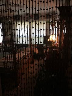 the room is very dimly lit by the light coming in through the iron bars on the door