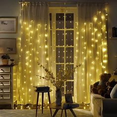 a living room with yellow curtains and lights on the windowsill, two small stools next to a coffee table