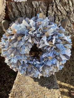 a wreath made out of blue and white paper on top of a wicker basket