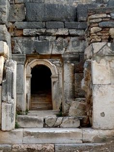 an old stone building with a doorway and steps