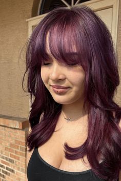 This hairstyle has a very colorful and bright purple color that gives a fun and daring change to the usual bangs cut. The bangs are cut in a gentle and wispy way that softly creates a frame around the face, offering a delicate feel and modern trend. Long, loose curls flow past the shoulders, making a look that catches the - Click to see more of Get the Look: 25 Hairstyles to Rock Sabrina Carpenter's Signature Bangs and follow us for more hairstyle ideas. // Photo Credit: Instagram @styledbynix_ Hair Color Purple Ideas, Different Ways To Color Hair, Medium Length Colored Hair, Hair Color Ideas For Bangs, Hair Cuts Ideas Bangs, Purple Hair With Curtain Bangs, Cute Haircuts Bangs, Brown And Coloured Hair, Fun Purple Hair