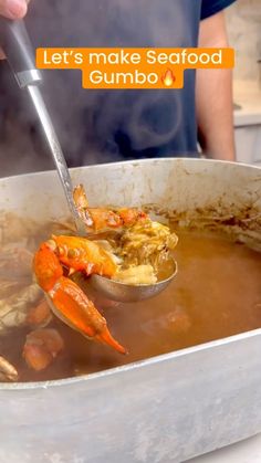 someone is cooking some food in a pot with a ladle full of soup and lobsters on the side